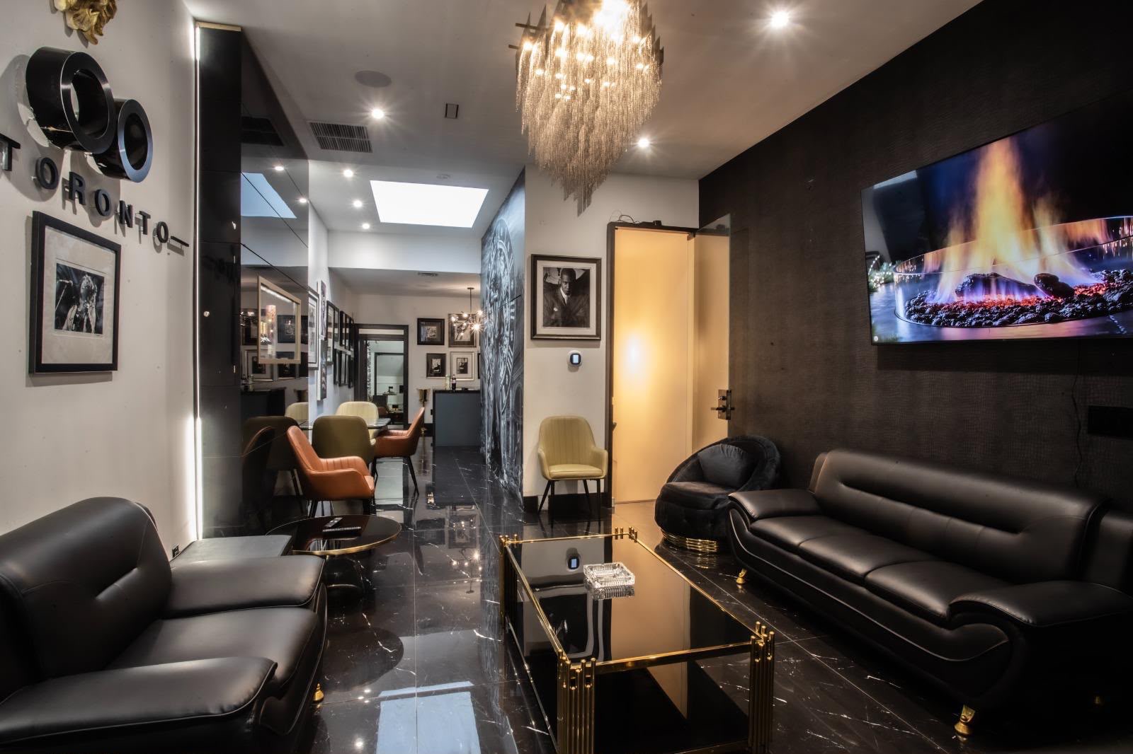 Private lounge with black leather seating, marble floors and a crystal chandelier