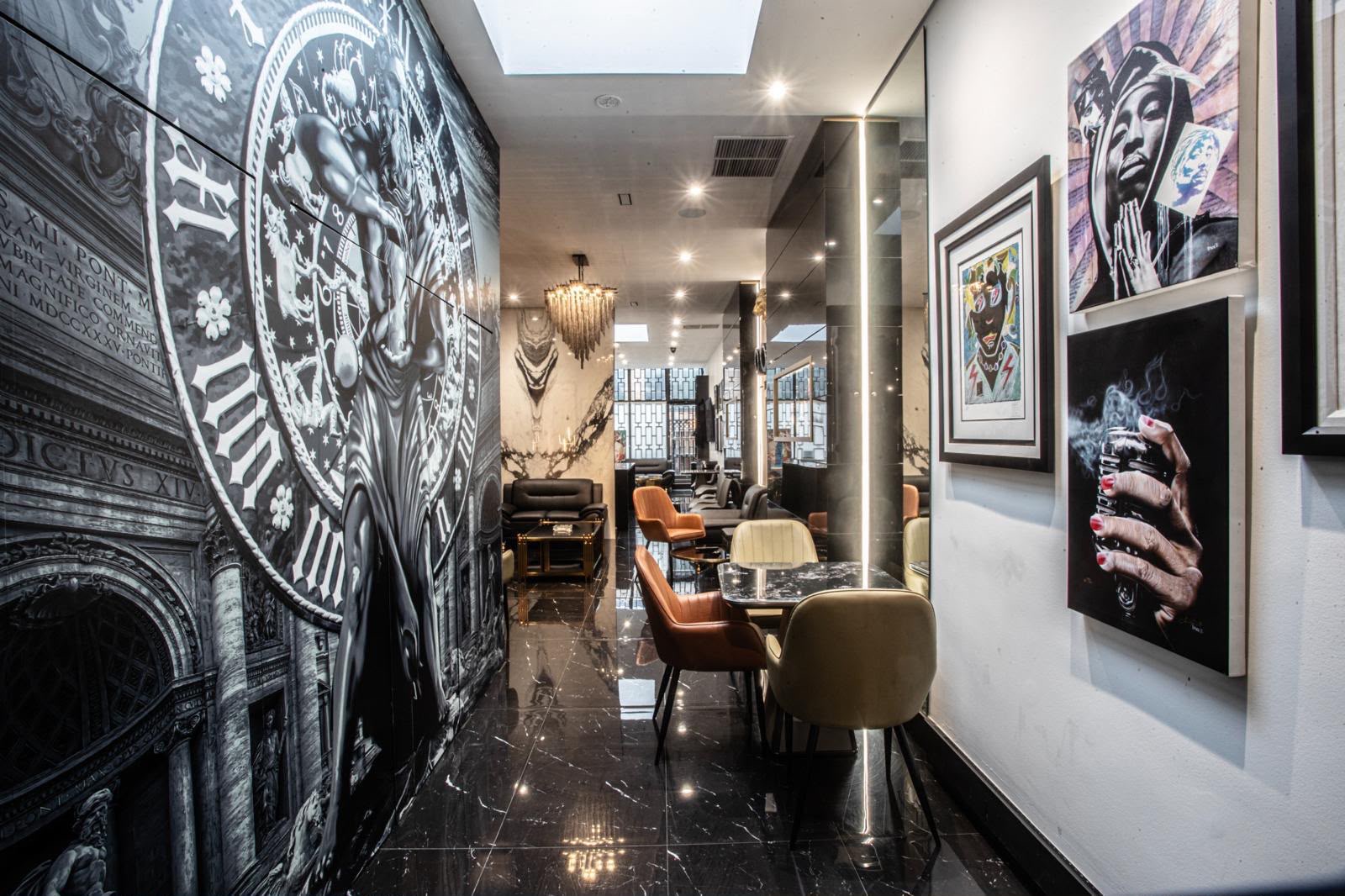 Hallway with mural artwork, framed portraits and marble tables